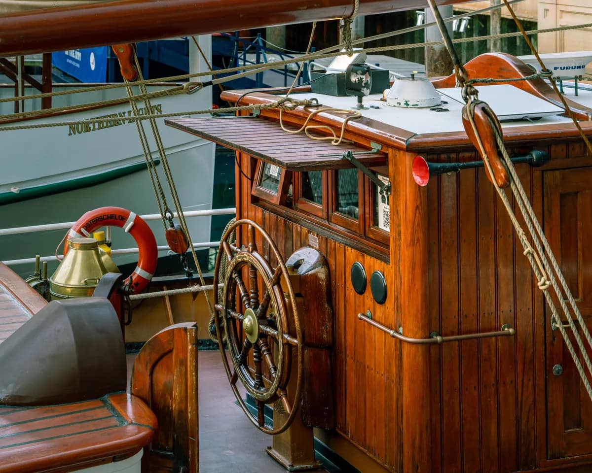 Exemple d'image BookNoFees : cabine en bois d'un bateau avec un gouvernail et une bouée de sauvetage