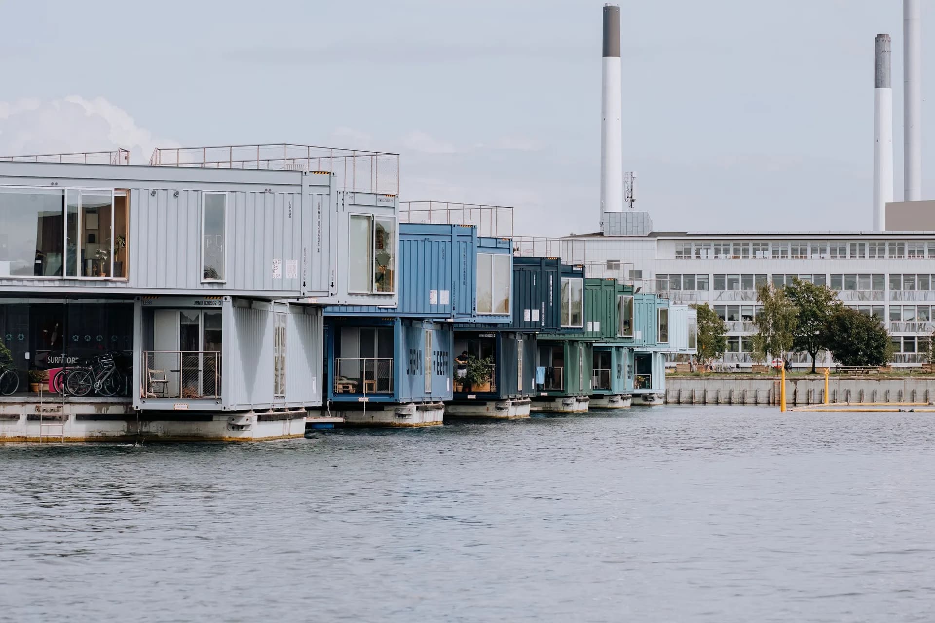 Exemple d'image BookNoFees : immeubles d'habitation en conteneurs à plusieurs étages au bord de l'eau, avec de grandes fenêtres