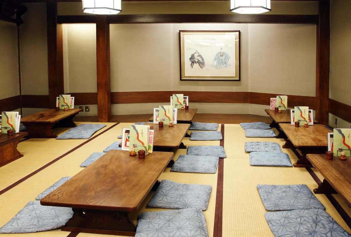 Exemple d'image BookNoFees : salle à manger japonaise avec des tables basses en bois et des coussins d'assise sur des tatamis