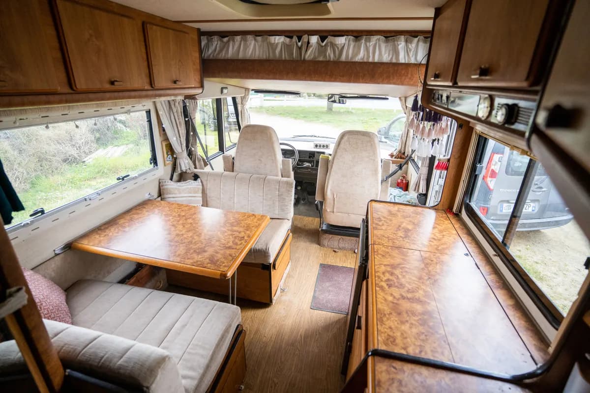 BookNoFees-voorbeeldfoto: interieur van een camper met keuken, tafel en gestoffeerde zitbanken