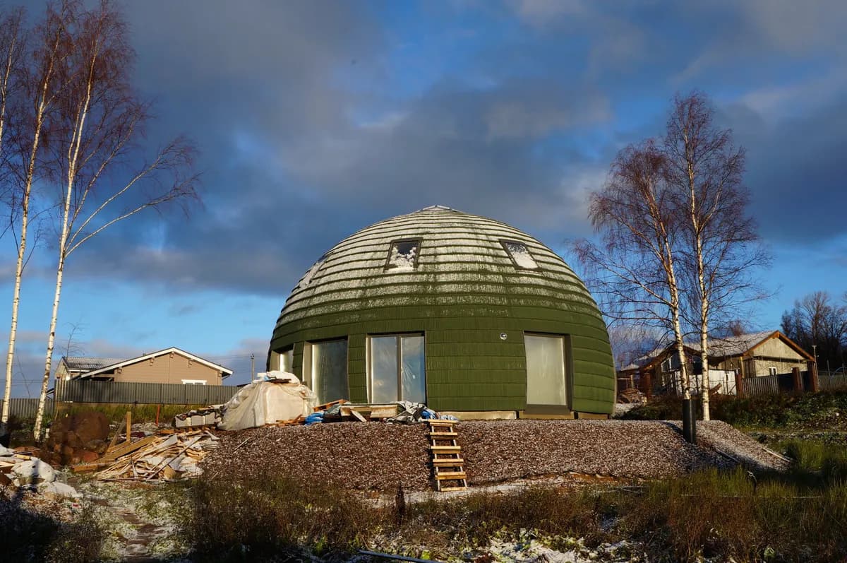 Exemple d’image BookNoFees : maison verte au toit en coupole sous un ciel bleu, sur un terrain verdoyant
