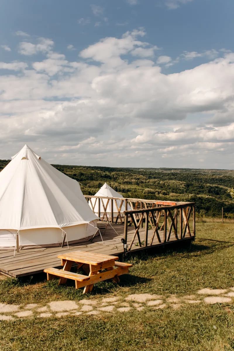 Exemple d'image BookNoFees : tentes de glamping installées sur des estrades en bois dans un paysage à perte de vue