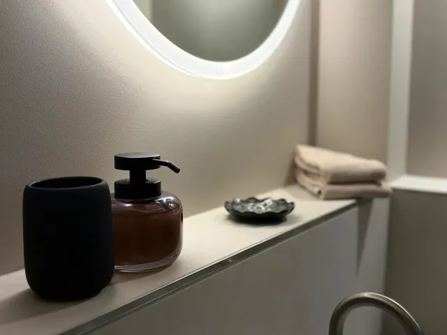 BookNoFees: Ferienwohnung in Sundern, Deutschland – Eine Flasche Seife steht auf einem Regal im Badezimmer. in der Unterkunft Alte Schmiede in Sundern
