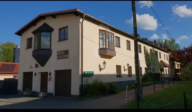 BookNoFees : location de vacances à Schönfeld, Saxe, Allemagne – Extérieur d'un bâtiment de deux étages avec des portes de garage, des baies vitrées et un panneau de rue