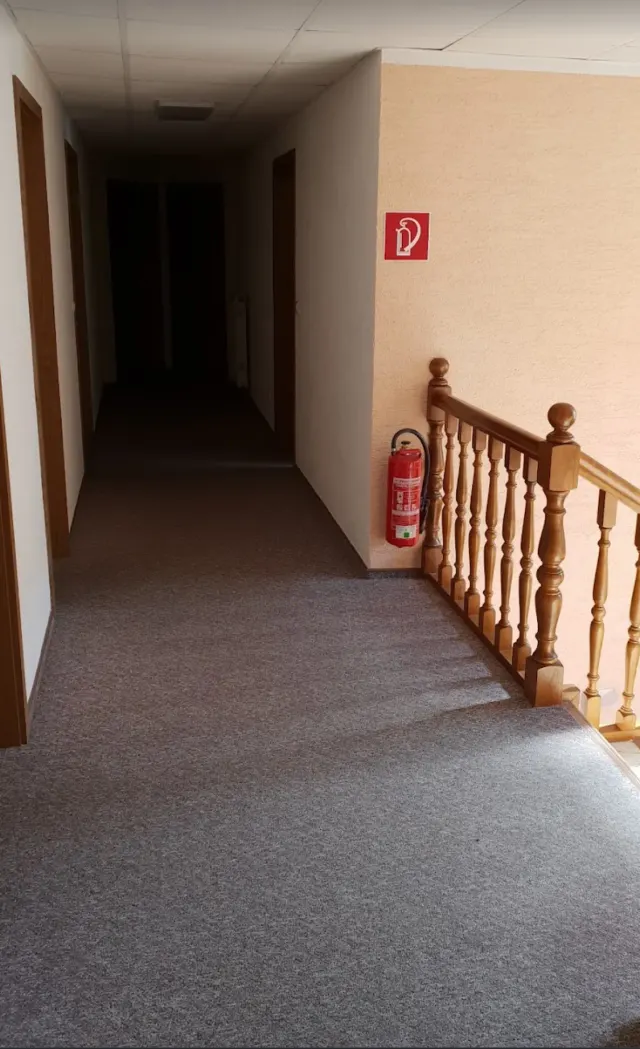 BookNoFees : location de vacances à Schönfeld, Saxe, Allemagne – Couloir de l'étage supérieur avec rampe en bois et extincteur