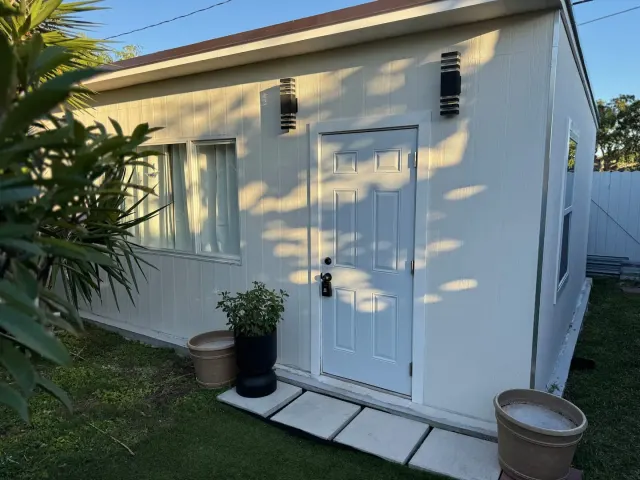 BookNoFees : location de vacances à Cutler Bay, États-Unis – Extérieur d'une petite maison blanche avec une porte d'entrée, des plantes en pot et un allée en pierre