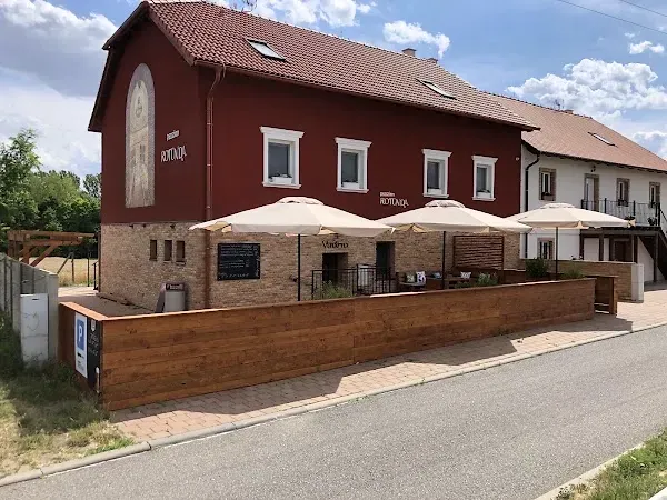 BookNoFees: vakantiehuis in Jevišovka, Regio Zuid-Moravië, Tsjechië – Buitenkant van een rood gebouw met terras en grote parasols
