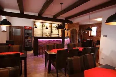 BookNoFees: vakantiehuis in Jevišovka, Regio Zuid-Moravië, Tsjechië – Restaurant met rode tafelkleden, houten balken en een bar met flessen