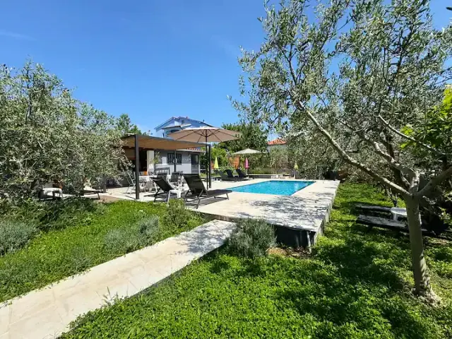 BookNoFees: vakantiehuis in Pula – Tuin met zwembad, ligstoelen, parasol en olijfbomen