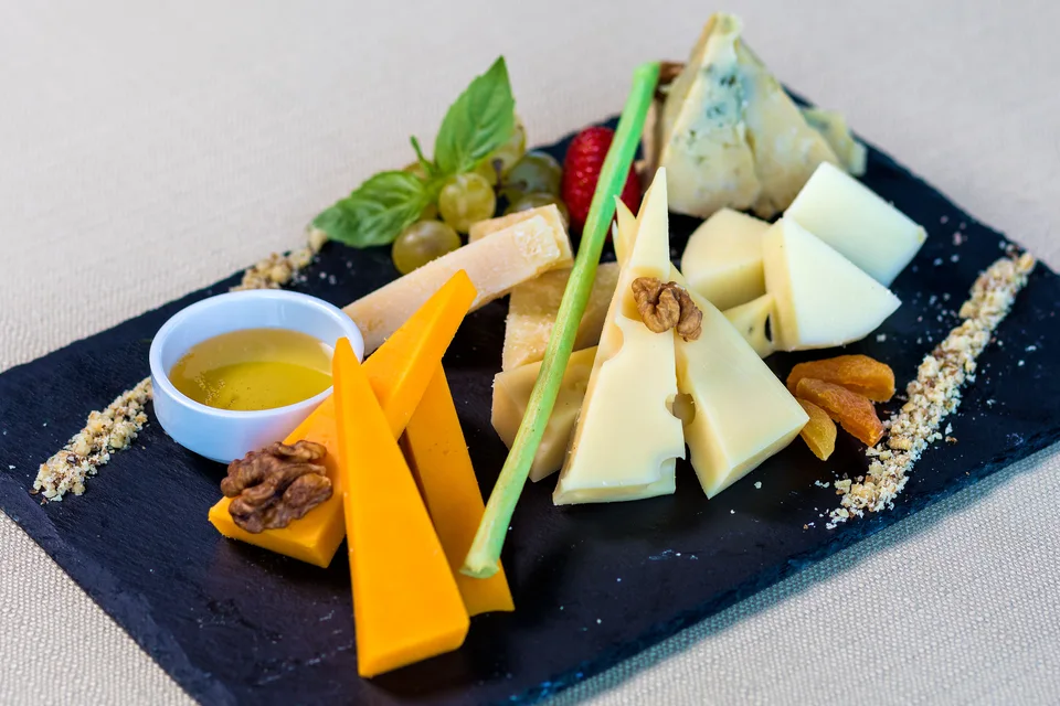 Voorbeeldfoto: Assortiment kazen met fruit en noten op een serveerplank