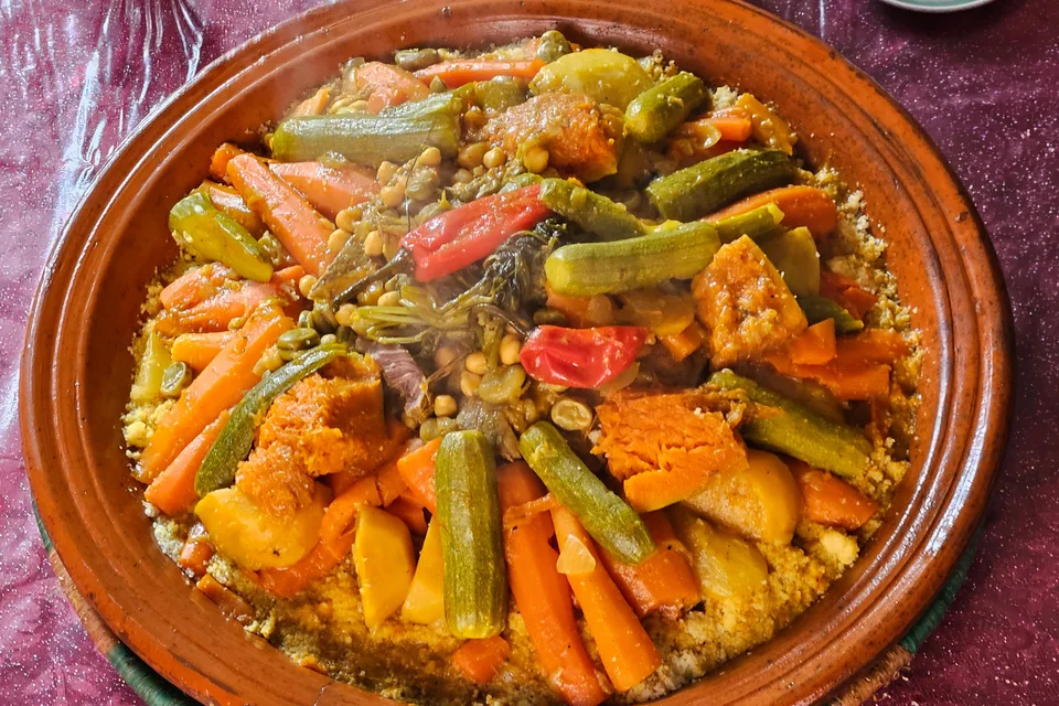 BookNoFees: Photo d’illustration : Des légumes colorés servis dans un tajine